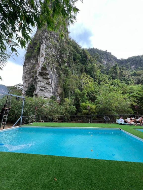 a blue swimming pool in front of a mountain at Mountain View Party Hostel in Ban Chong Phli
