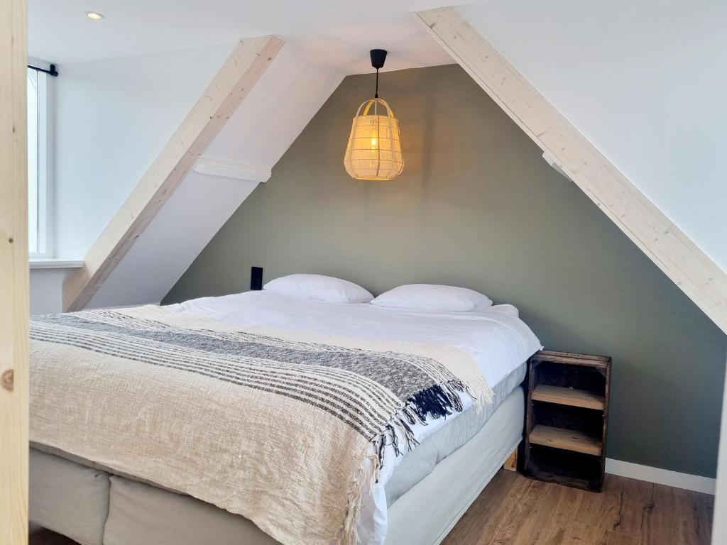 ein Schlafzimmer mit einem weißen Bett und einer Lampe in der Unterkunft Tip! Noordwijk city center house in Noordwijk aan Zee