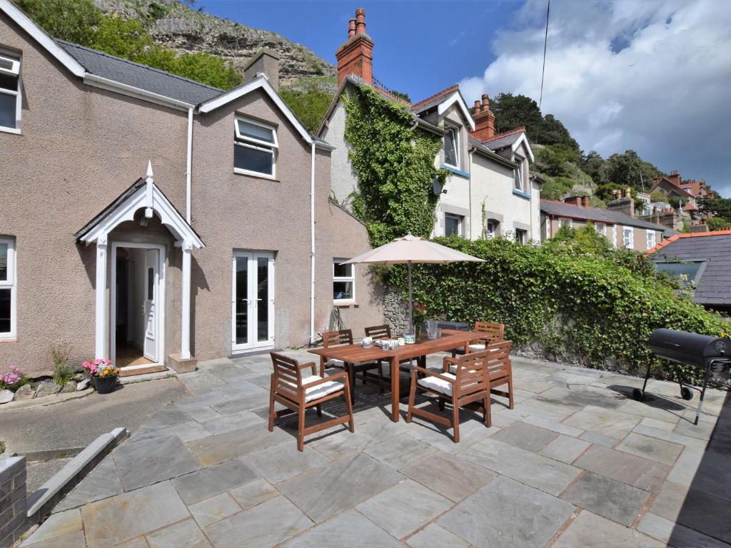 a patio with a table and chairs and an umbrella at 3 Bed in Llandudno 89331 in Llandudno