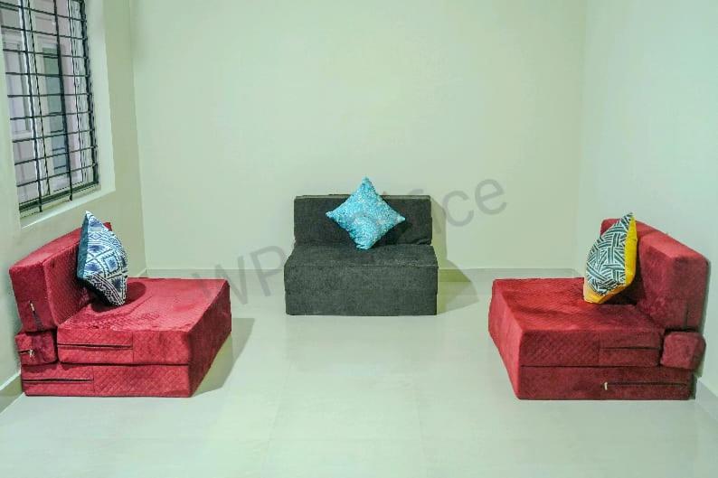 un grupo de tres sillas de colores diferentes en una habitación en GMR Suites en Kalpatta