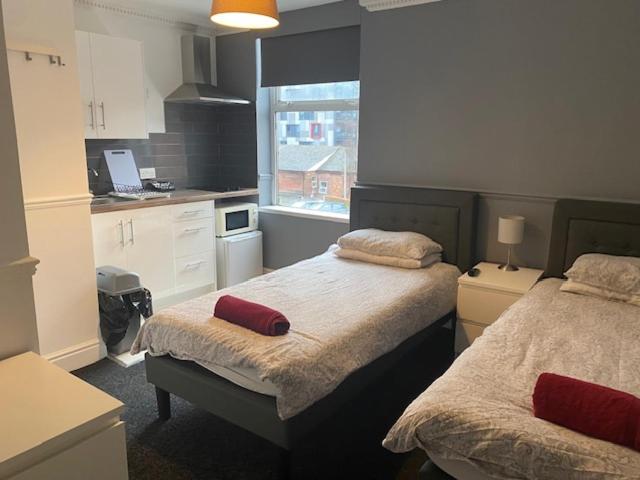 sypialnia z 2 łóżkami i kuchnia z oknem w obiekcie Circle Guest House Bed Only w Southampton