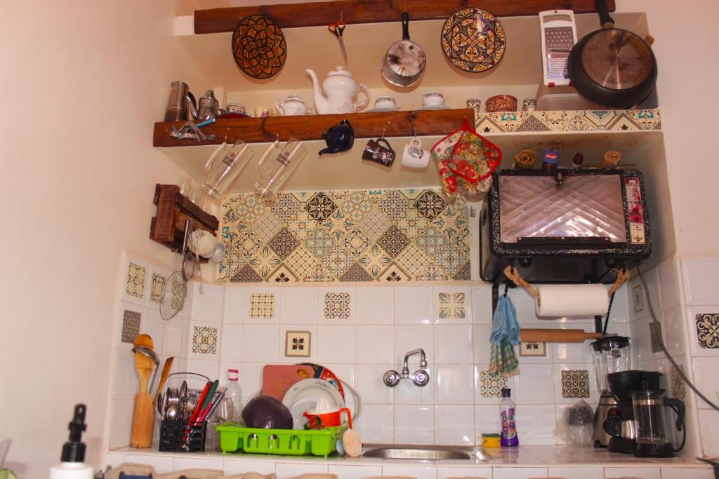 a kitchen with lots of dishes and utensils on the wall at Asunfou : Appartement d'apaisement in Mirleft