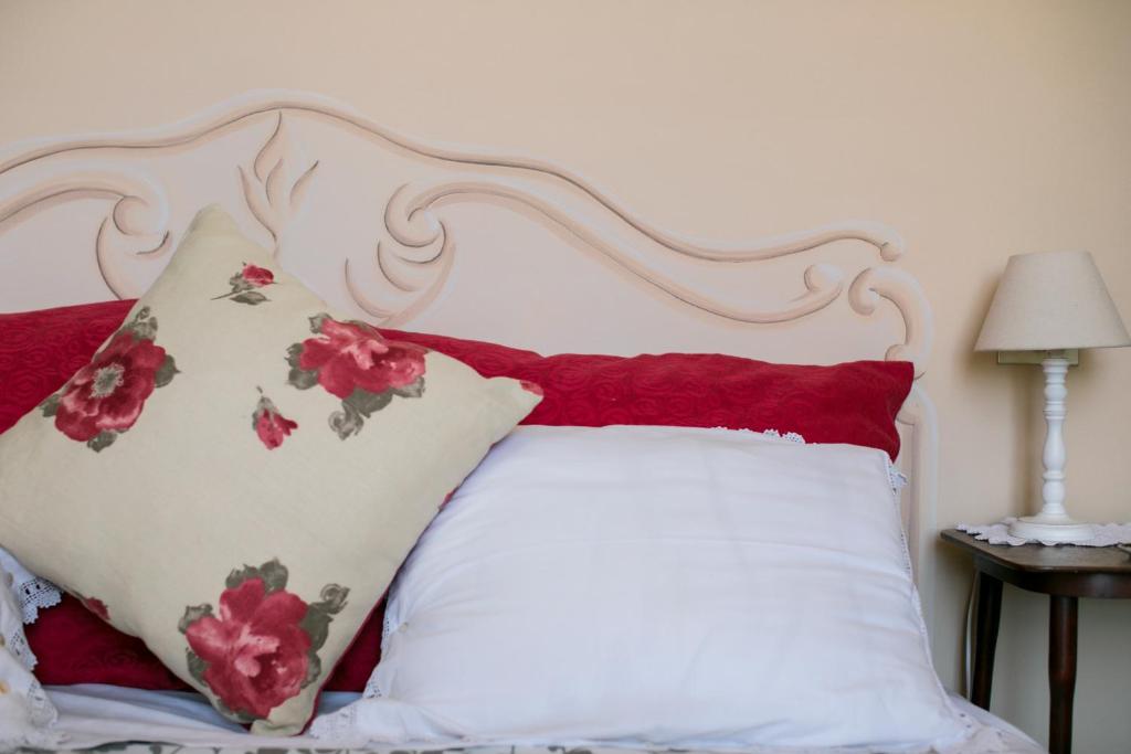a bed with red and white pillows on it at B&B Agapantus in una Villa dell'800 in Dolceacqua