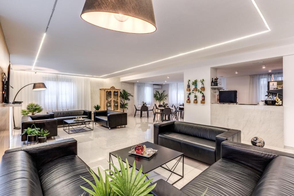 a living room with black leather couches and tables at Casena Dei Colli, Sure Hotel Collection By Best Western in Palermo