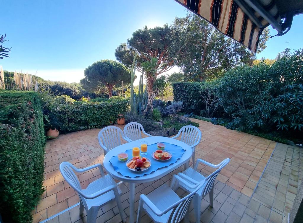 - une table et des chaises sur une terrasse en briques dans l'établissement Acanthes - Appartement avec jardin - À 5 minutes des plages, au Lavandou