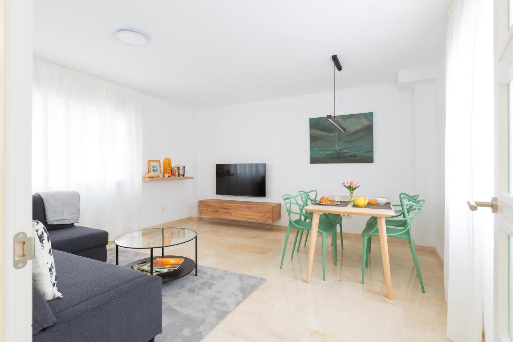 sala de estar con mesa y TV en OceanVibe Loft MalagaFlat en Málaga