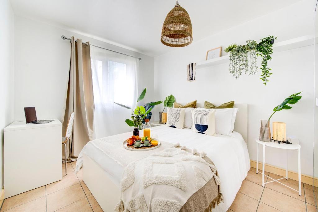 een witte slaapkamer met een bed en een dienblad met fruit erop bij BOHO Chic Tower Bridge Gem, Sleeps 8 in Londen