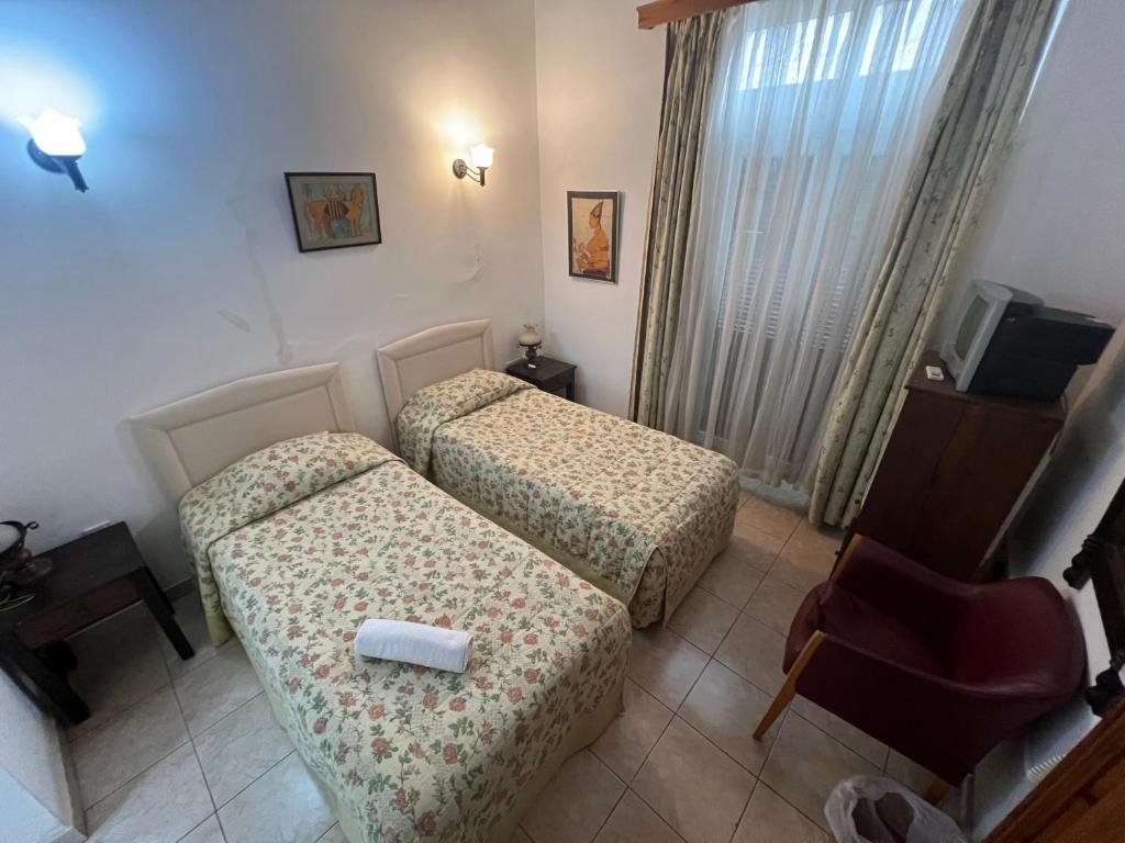 a hotel room with two beds and a chair at Nostalgia Boutique Hotel Girne in Kyrenia