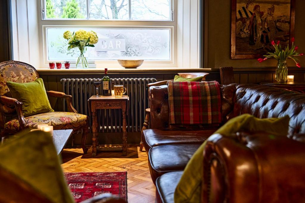 a living room with leather furniture and a window at The Black Horse, Climping in Climping