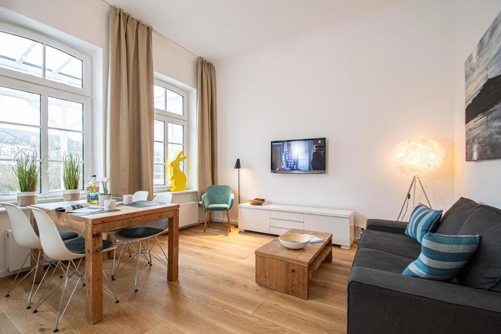 a living room with a table and a couch at Georg6 GEORG6 - Fewo 5 in Norderney