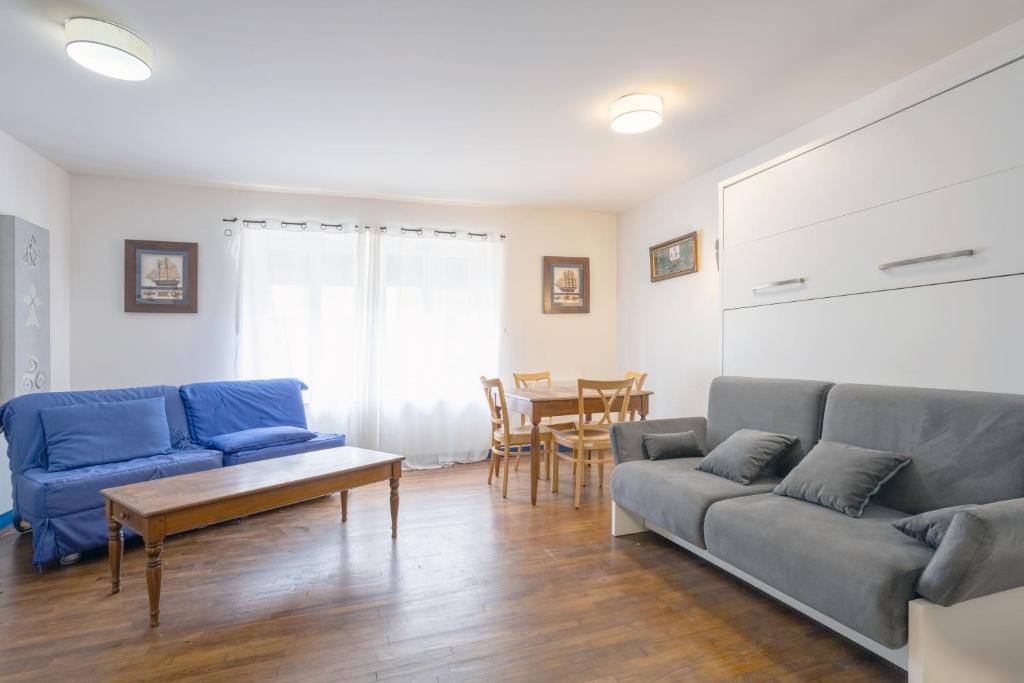 ein Wohnzimmer mit 2 blauen Sofas und einem Tisch in der Unterkunft Appartement 4 pers 400m de la plage in Le Guilvinec