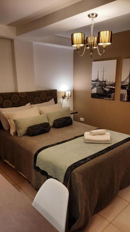 MODERNO MONOAMBIENTE CALIDAD SUPERIOR في صنتشيلس: غرفة نوم بسرير كبير وكرسي أبيض