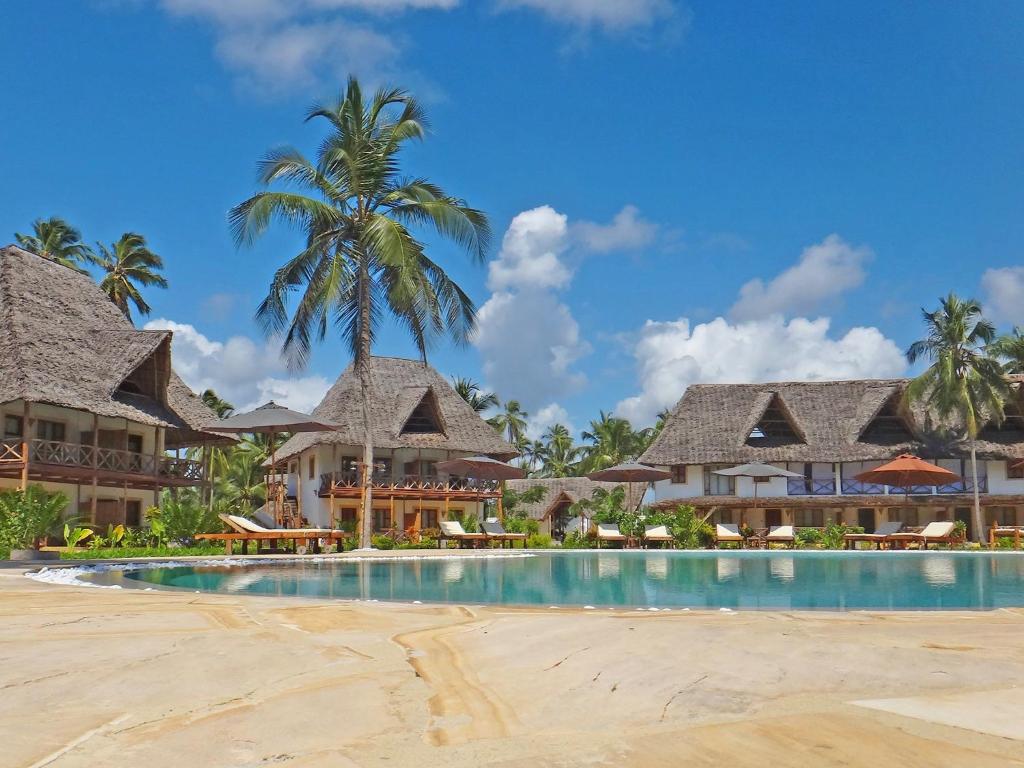 a resort with a swimming pool and palm trees at Pongwe Bay Resort in Pongwe