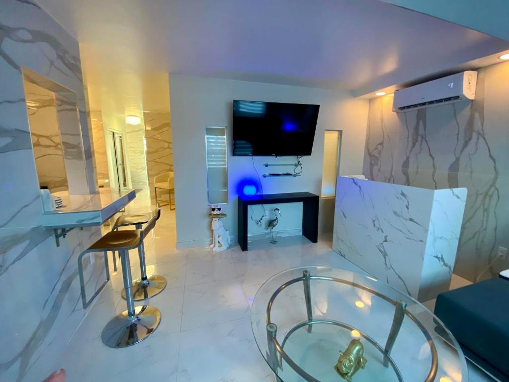 uma sala de estar com uma mesa de vidro e uma televisão em Luxurious remodeled direct Waterfront apartment with Miami skyline view and outdoor terrace Free parking 5min drive to Miami Beach em Miami Beach
