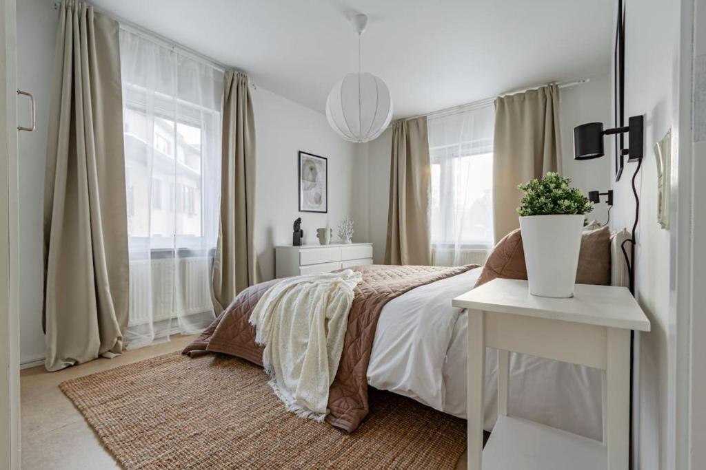 a white bedroom with a bed and a table at Sodermalm Hideaway Haven in Stockholm
