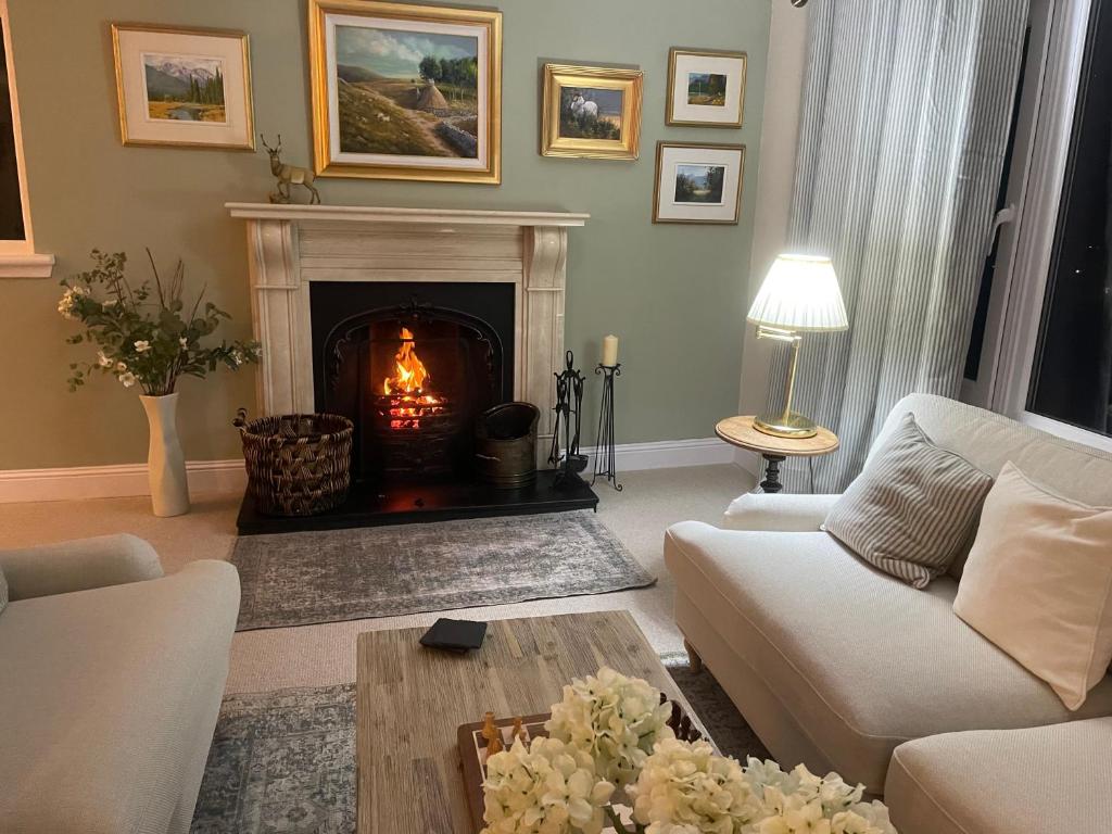 a living room with a fireplace with a couch and a table at Castlecroft Bed and Breakfast in Stirling