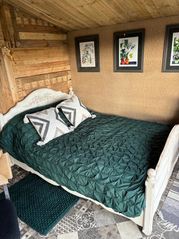 a bed with a green comforter in a room at The Deer Hut at Carr House Farm in Scarborough
