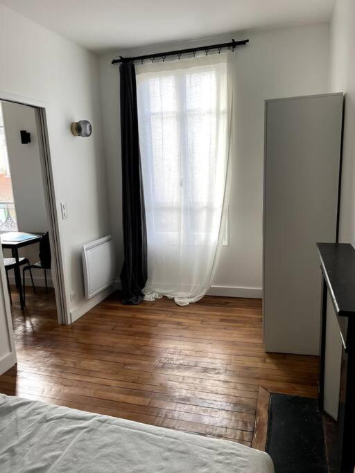 a bedroom with a window and a wooden floor at Charmant 2 pièces proche RER B direction Paris in Fontenay-aux-Roses