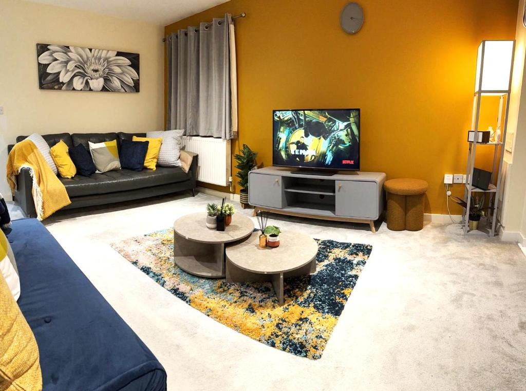 uma sala de estar com um sofá e uma televisão em Large Cosy 2 bedroom Apartment in Stevenage SG1 Sleeps 5 em Stevenage