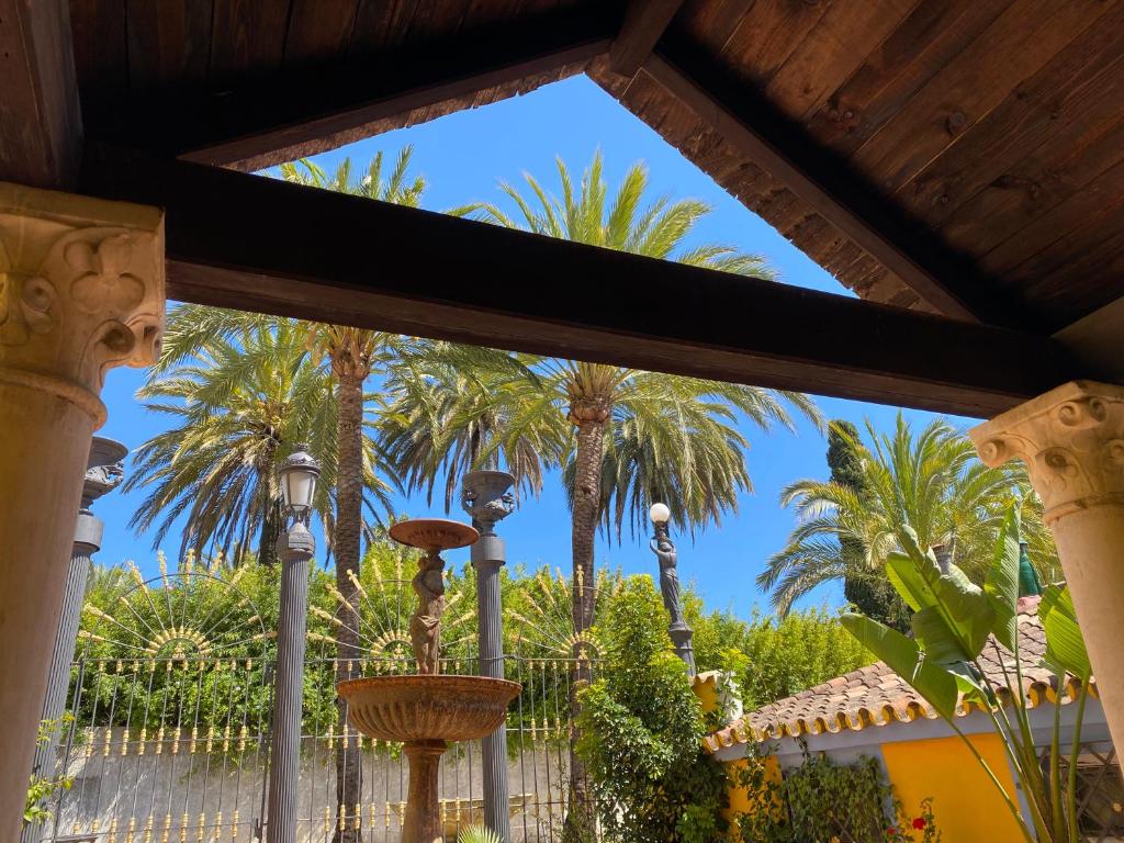 マルベーリャにあるCortijo La Saleta Banúsの椰子の木の景色を望むポーチ