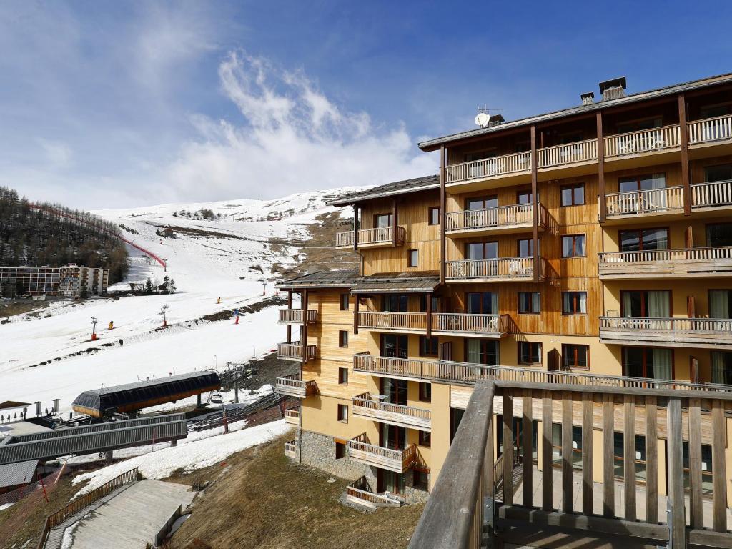 un chalet de ski avec une montagne enneigée en arrière-plan dans l'établissement A209- Appartement 2 pieces cabine 6 personnes, à Orcières