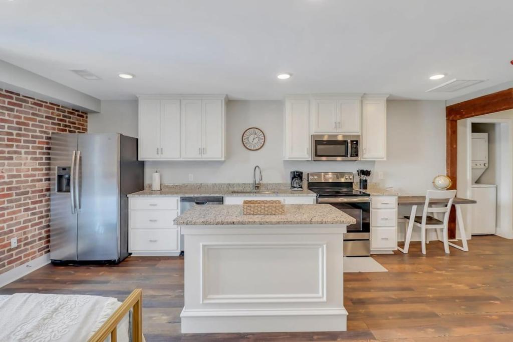a kitchen with white cabinets and stainless steel appliances at The Post Suite - above Bull & Barrel Close to GSU in Statesboro