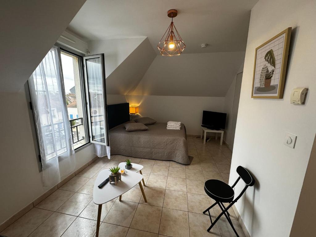 a bedroom with a bed and a table and chairs at Le studio du 72 in Bussy-Saint-Georges