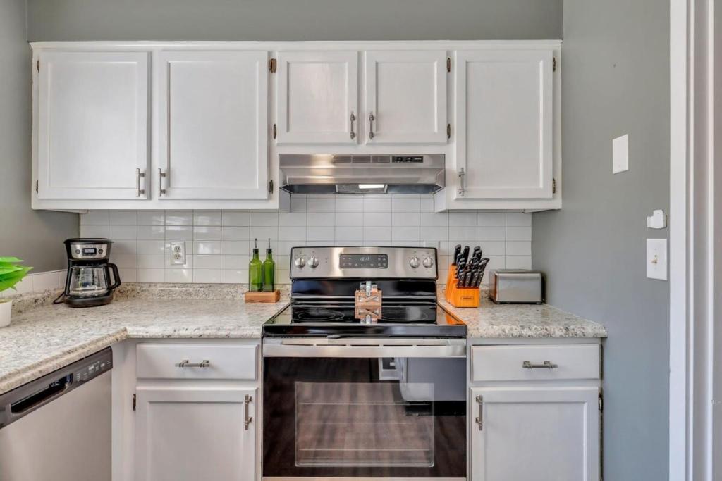 a kitchen with white cabinets and a stove top oven at GATA 2 -The Rustic Suite - Close to GSU in Statesboro