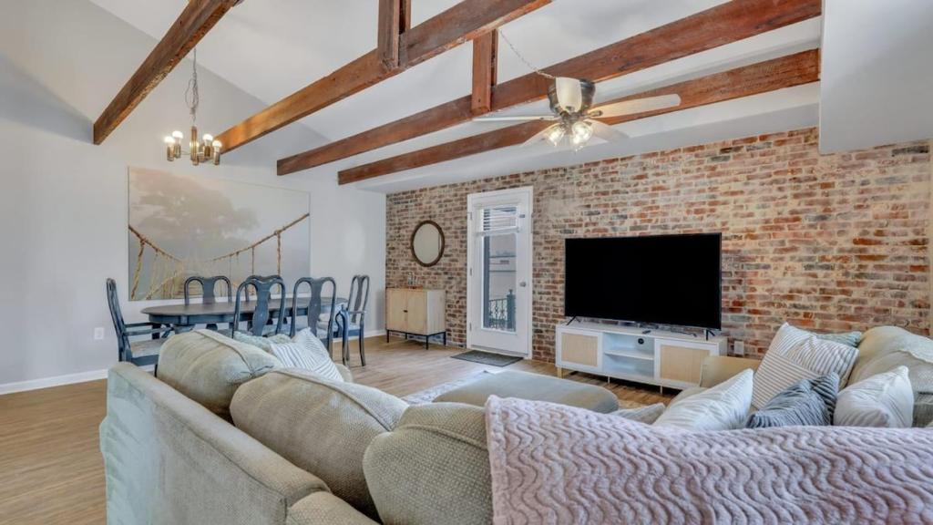a living room with a couch and a brick wall at Eagle's Roost Retreat - Near GSU in Statesboro