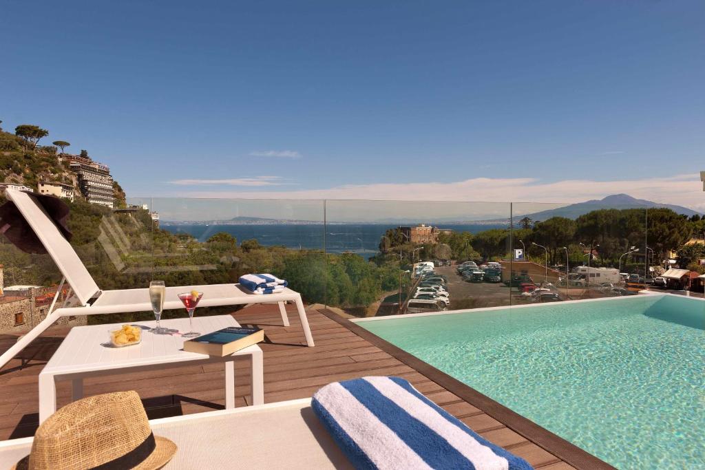 a pool with a table and chairs next to a building at Hotel Rivage in Sorrento