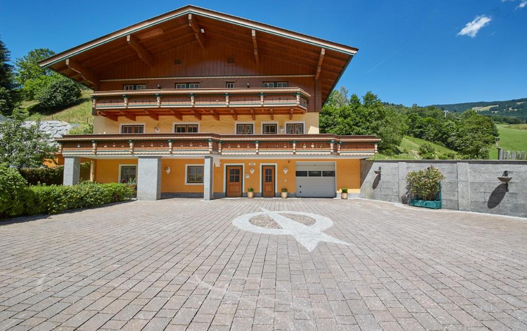 a large house with a large driveway in front of it at Appartements 4-You in Saalbach Hinterglemm