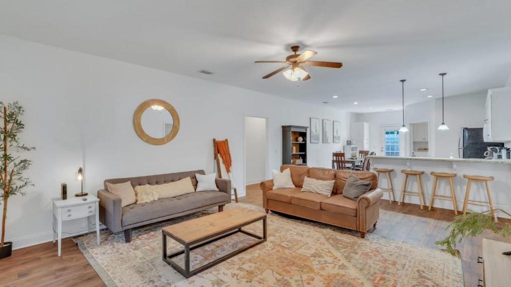 a living room with two couches and a kitchen at Eagle's Retreat - Close to GSU & Paulson Stadium in Statesboro