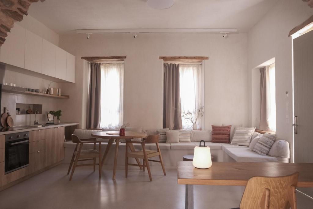 Il comprend une cuisine et un salon avec une table et un canapé. dans l'établissement enδόtera chios apartments, à Chios