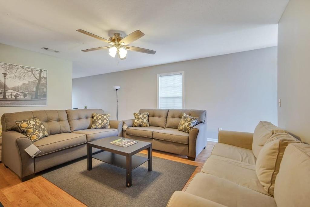 a living room with two couches and a ceiling fan at Charming Gray Home- 5 mins from GSU! in Statesboro