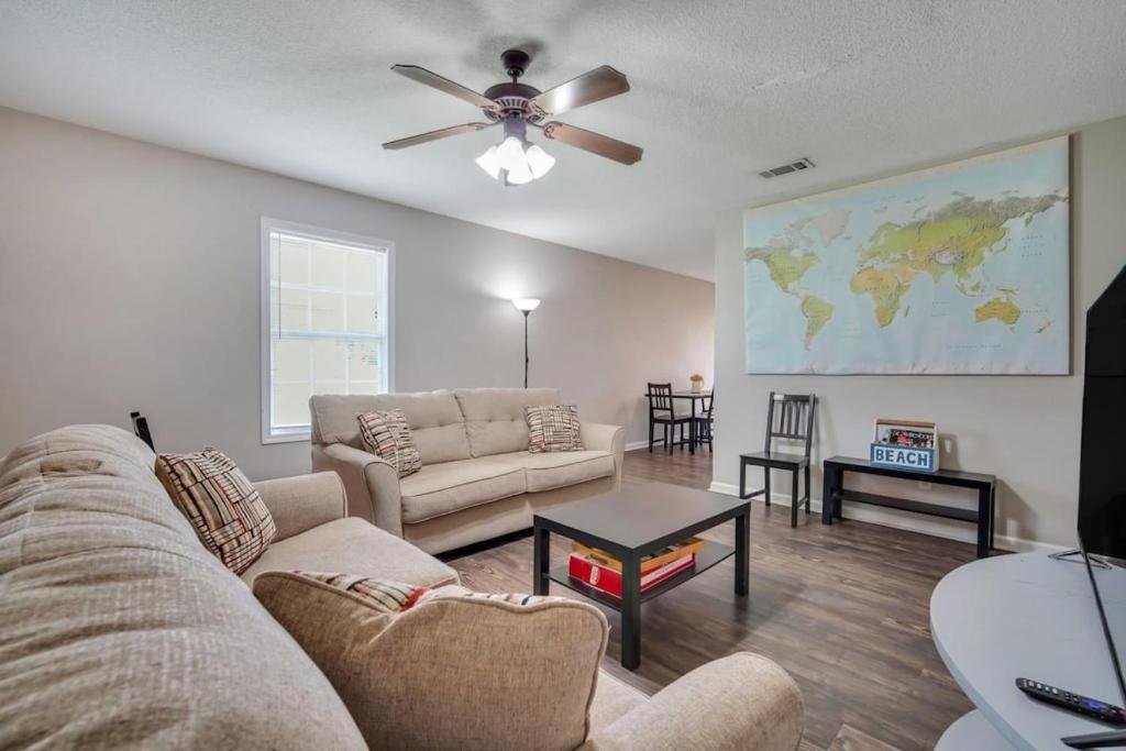 a living room with a couch and a ceiling fan at Cozy and Contemporary Villa 1 Mile from GSU in Statesboro