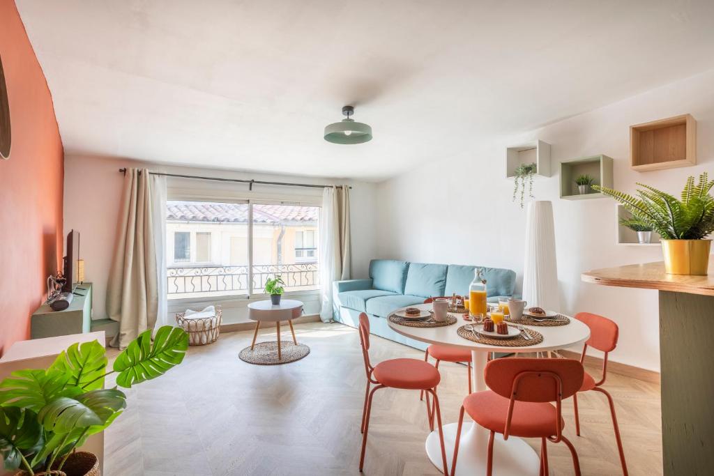 un salon avec un canapé bleu, une table et des chaises dans l'établissement Magnifique appartement rénové, à Aix-en-Provence