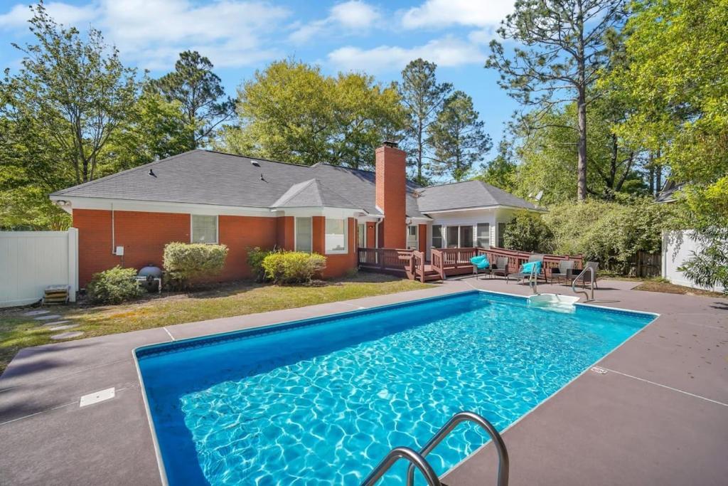 una casa con piscina frente a una casa en Market District Pool House, en Statesboro