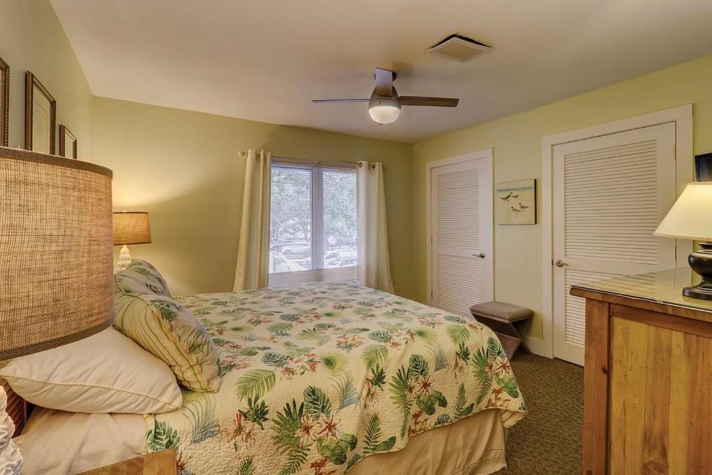 um quarto com uma cama e uma janela em Fraser's Folly - Updated Harbour Town Villa em Hilton Head Island