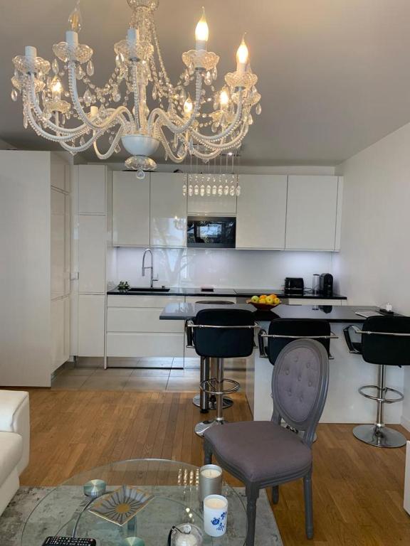 Il comprend un salon avec un lustre et une cuisine. dans l'établissement Pantin Bord du Canal JO 2024, à Pantin