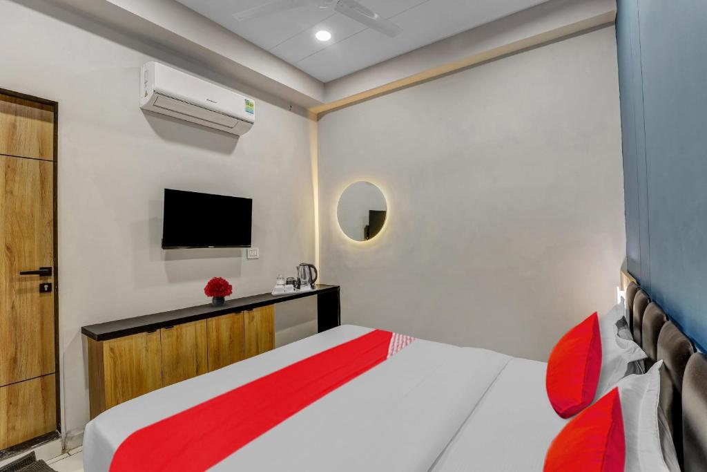 a bedroom with a bed and a tv on the wall at OYO Hotel Grand View in Surat