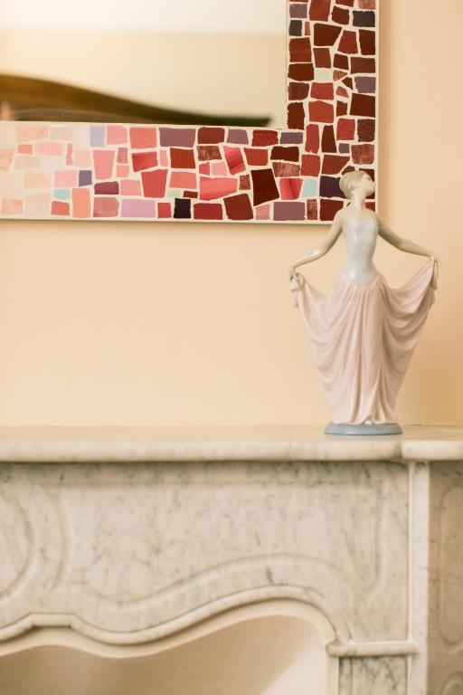 a statue of a woman sitting on top of a fireplace at B&B Agapantus in una Villa dell'800 in Dolceacqua