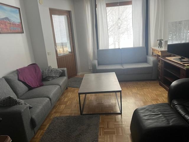 a living room with a couch and a coffee table at Hyvällä sijainnilla iso kaksio Hervannassa in Tampere