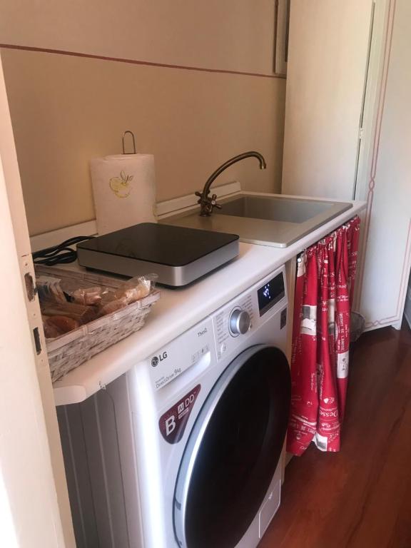 a kitchen with a washing machine with a sink at B&B Agapantus in una Villa dell'800 in Dolceacqua