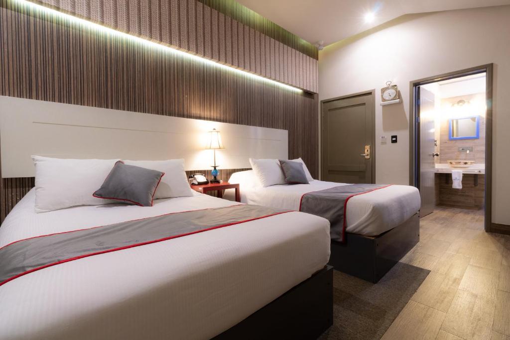 a hotel room with two beds and a bathroom at Collection O Coraz&oacute;n Del Caf&eacute; Hotel Boutique in Comit&aacute;n de Dom&iacute;nguez