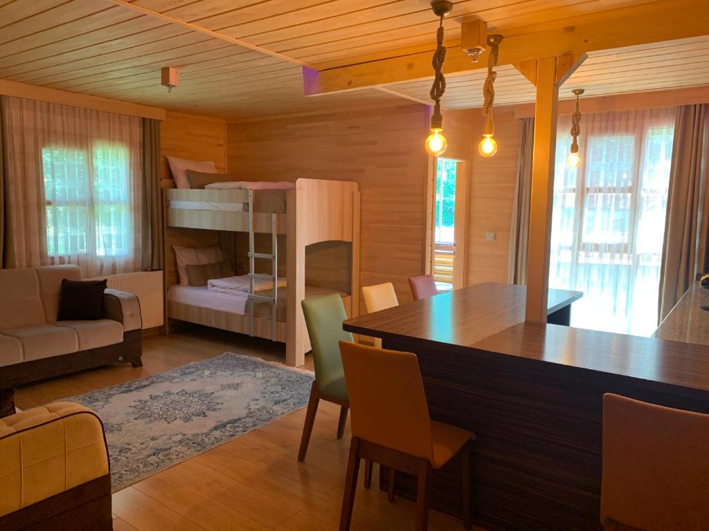 a living room with a table and a bunk bed at Bavul Suite in Uzungöl