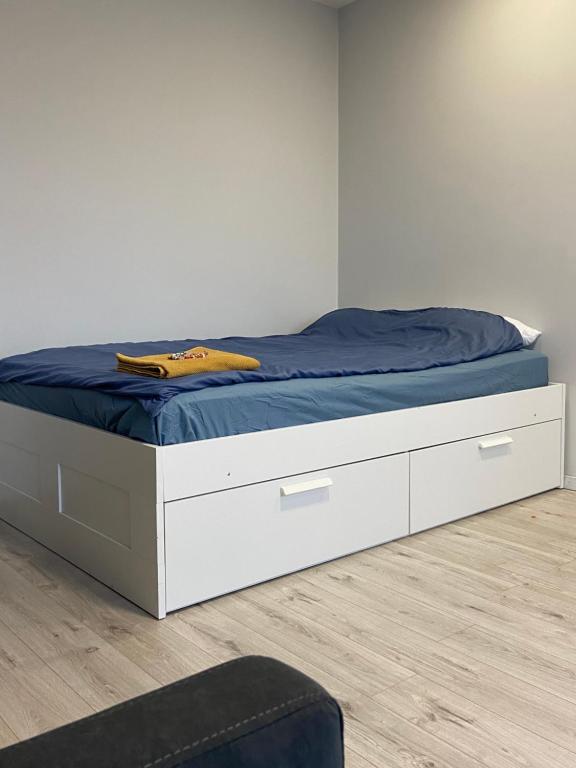 a bedroom with a bed with a blue blanket on it at Ziemeļblāzma in Rīga