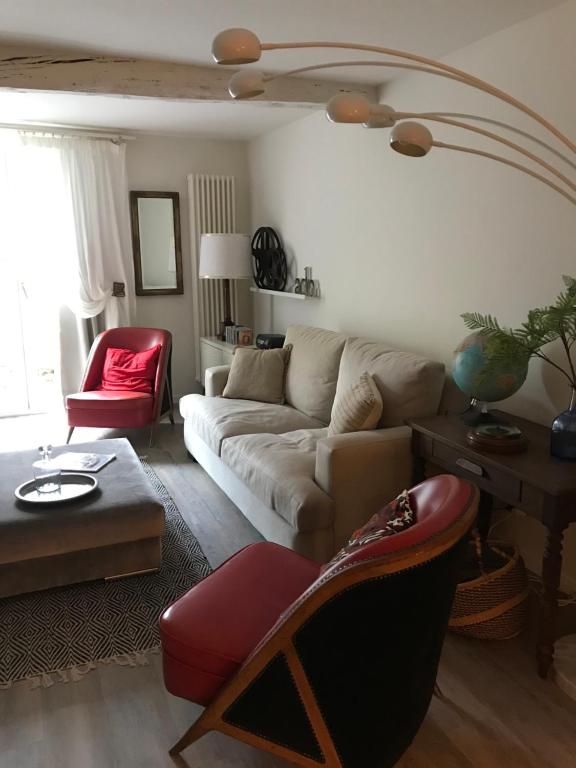 a living room with a white couch and a red chair at donibane20 EBI02770 in Orduña