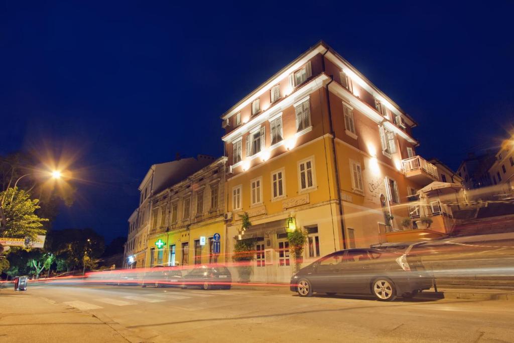 a building with a car driving down a street at night at Hotel Scaletta in Pula