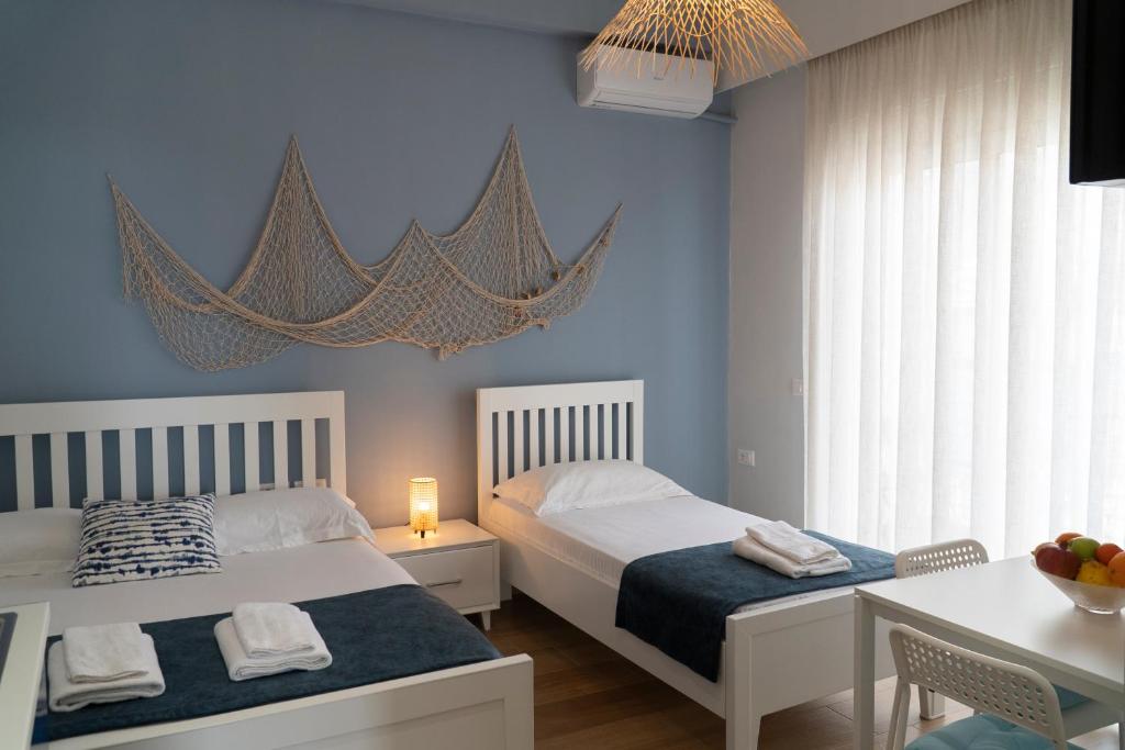 1 dormitorio con 2 camas, escritorio y mesa con mesa en Memories Apartments en Sarandë