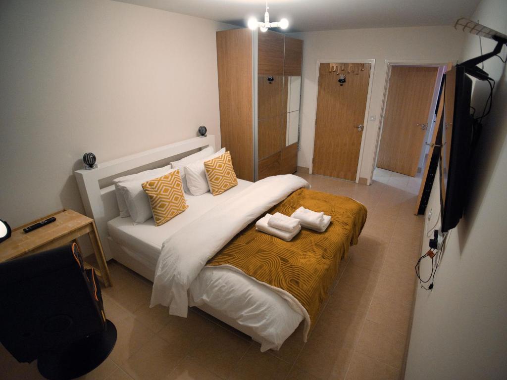 een slaapkamer met een groot wit bed met gele kussens bij Spacious 1 bed, terrace, garden, Colindale St in Colindale
